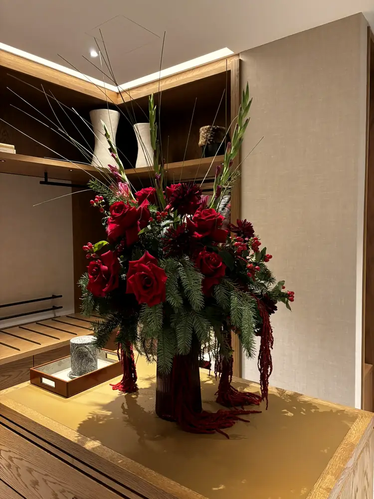 Arrangement of roses and amaranthus on an oak cabinet