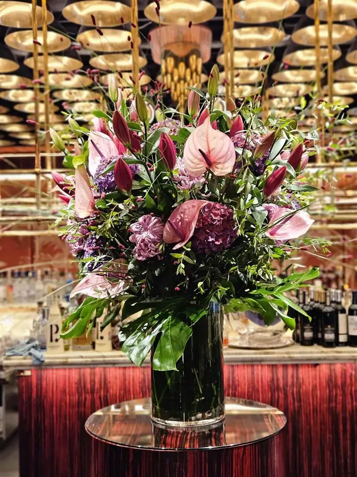 Tall vase of pink flowers in a restaurant