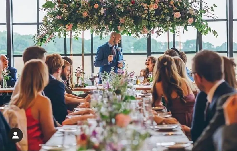 Long wedding table with flowers in a glasshouse