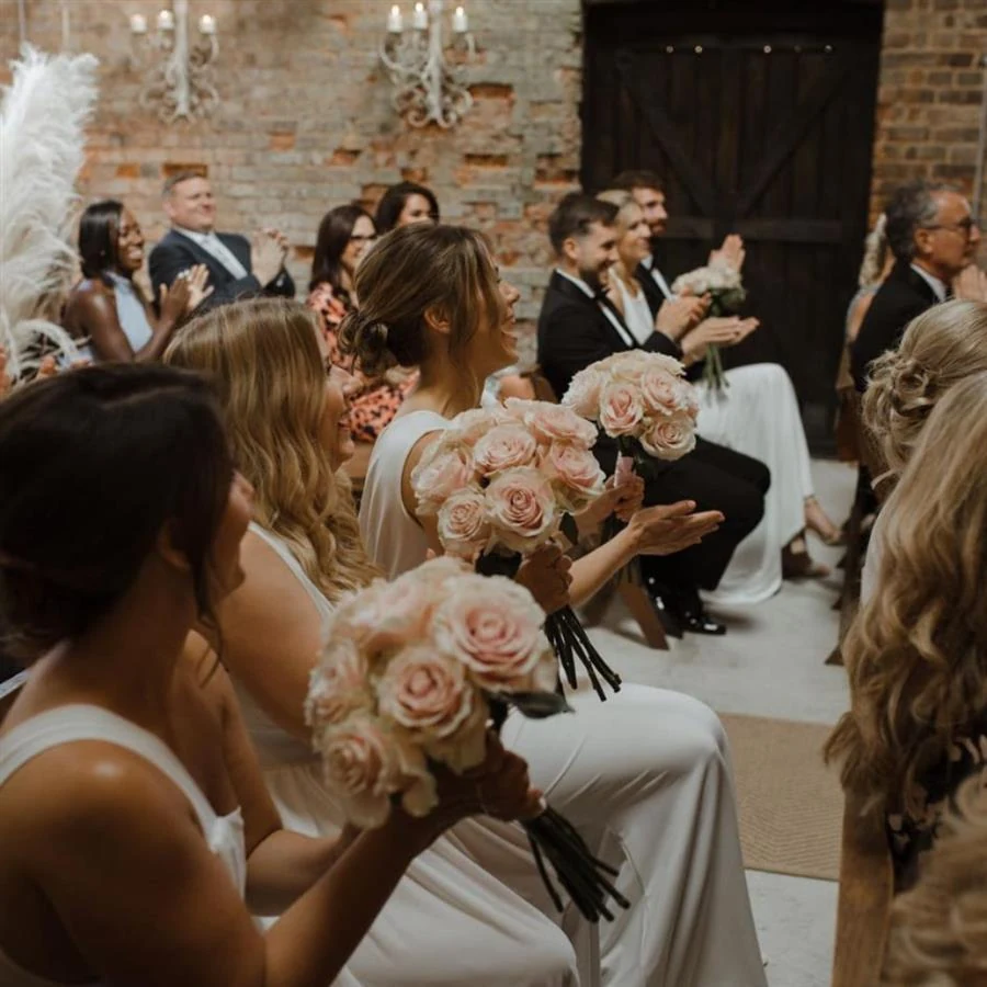 Bridesmaids raising their bouquets